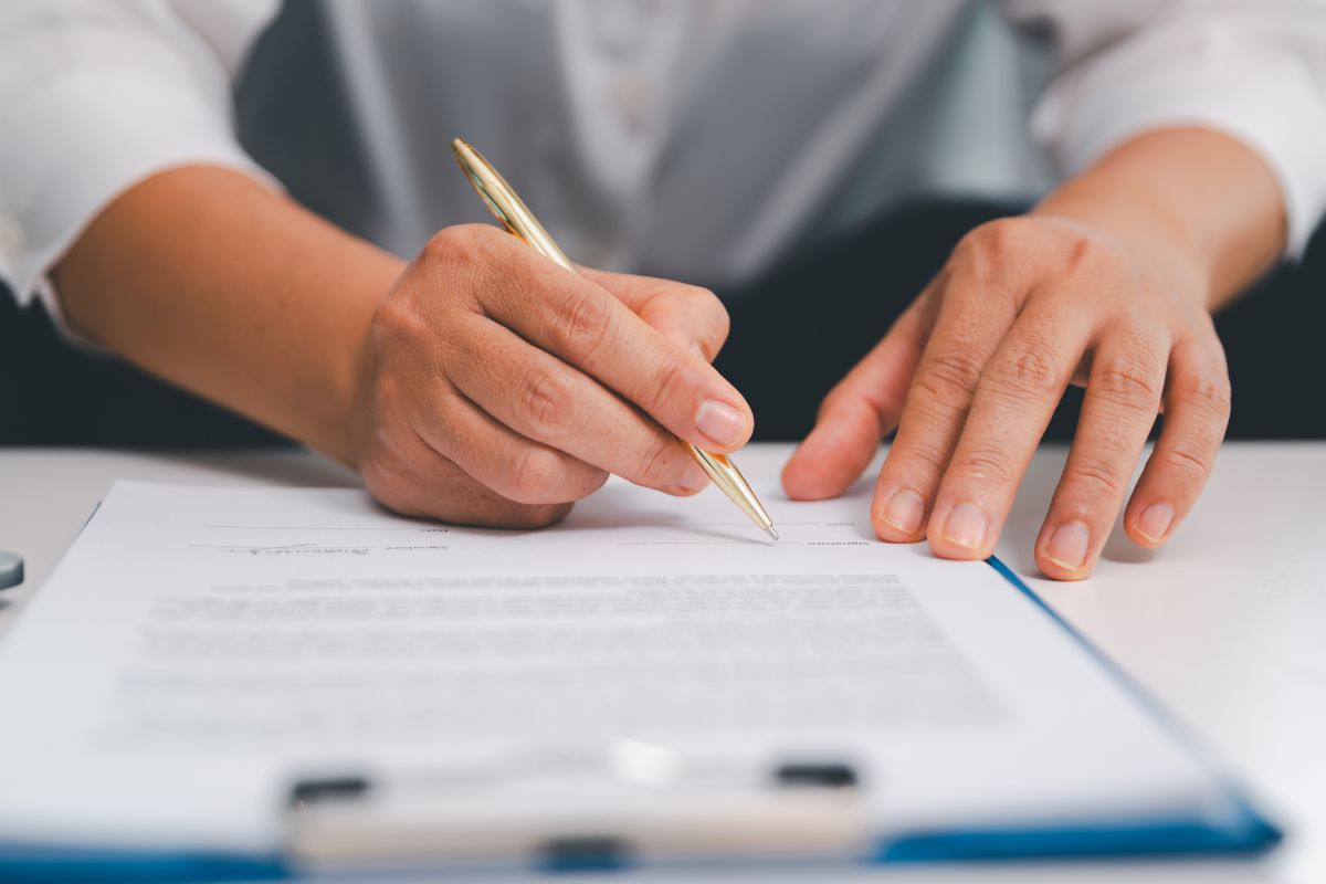 Persona firmando documentación para organizar un retiro en Bali legalmente